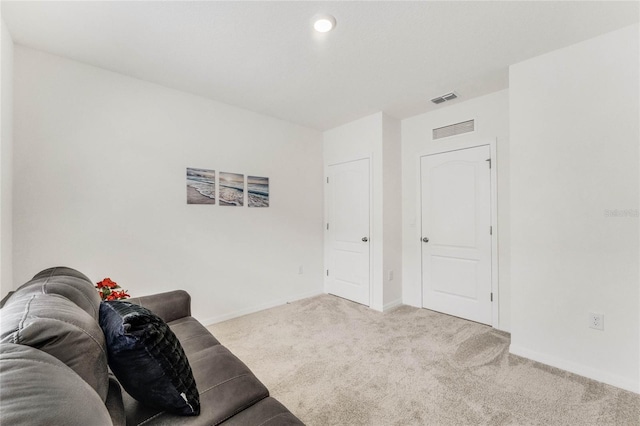 interior space featuring baseboards, visible vents, and light colored carpet