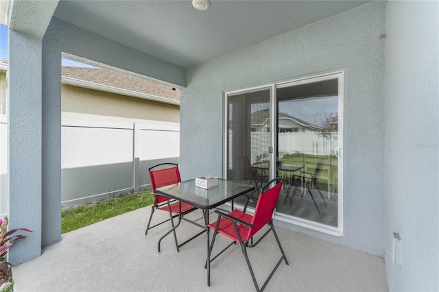 view of patio with outdoor dining space and fence