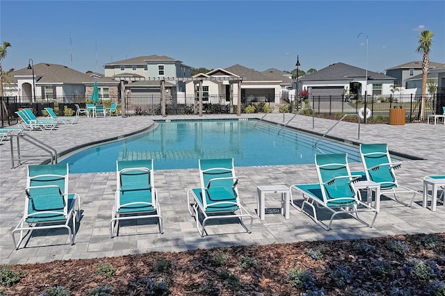 pool featuring a residential view, fence, and a patio