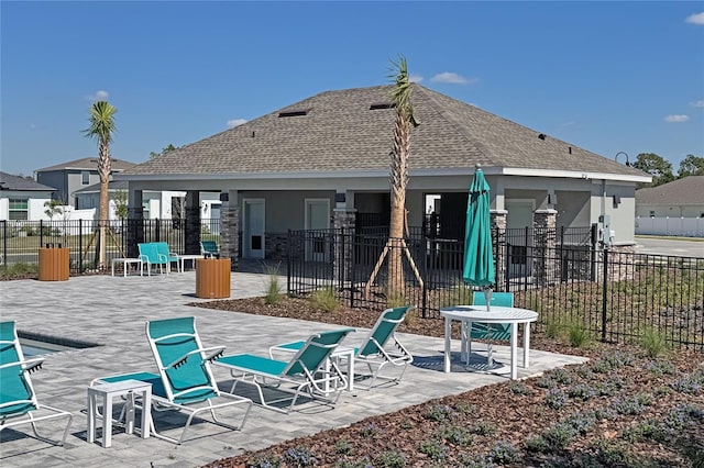 back of house with a patio area, a shingled roof, fence, and stucco siding