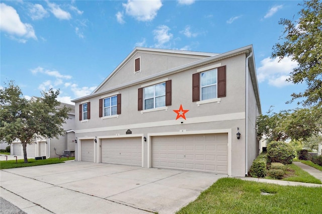 view of front of house featuring concrete driveway, an attached garage, and stucco siding