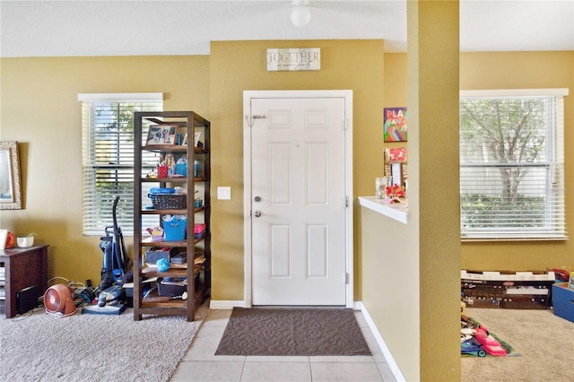 entryway with baseboards and light tile patterned flooring