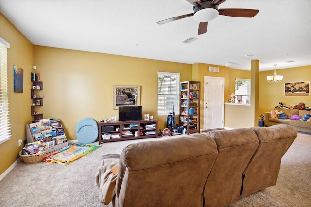 carpeted living area with baseboards, visible vents, and ceiling fan with notable chandelier