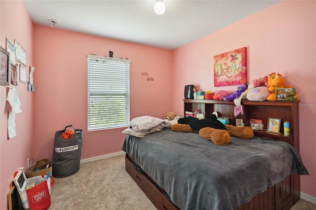 bedroom with light carpet and baseboards