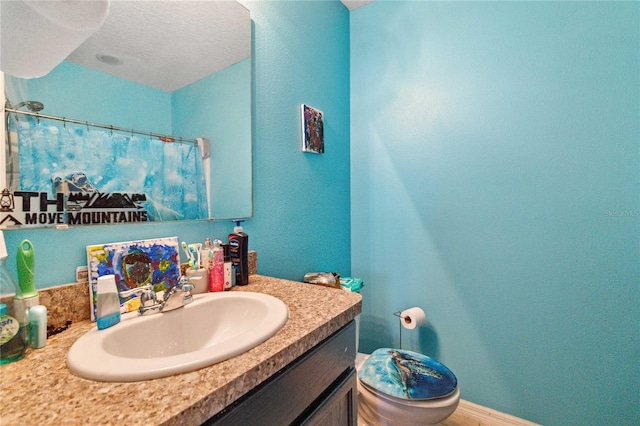 bathroom with toilet, vanity, and baseboards