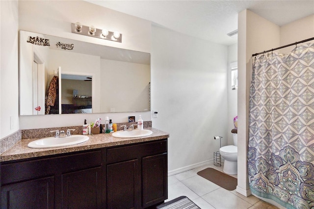 full bath with double vanity, a sink, toilet, and tile patterned floors