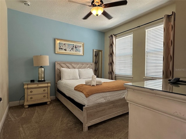 bedroom with baseboards, dark carpet, ceiling fan, and a textured ceiling