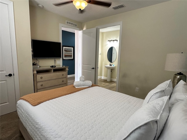 bedroom featuring a ceiling fan, baseboards, visible vents, and connected bathroom