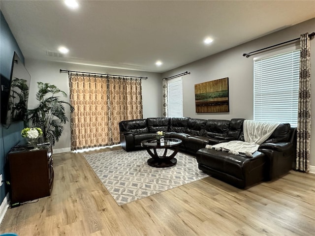 living area with baseboards, wood finished floors, visible vents, and recessed lighting