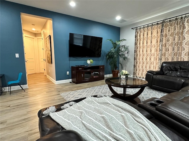 living area featuring visible vents, baseboards, wood finished floors, and recessed lighting