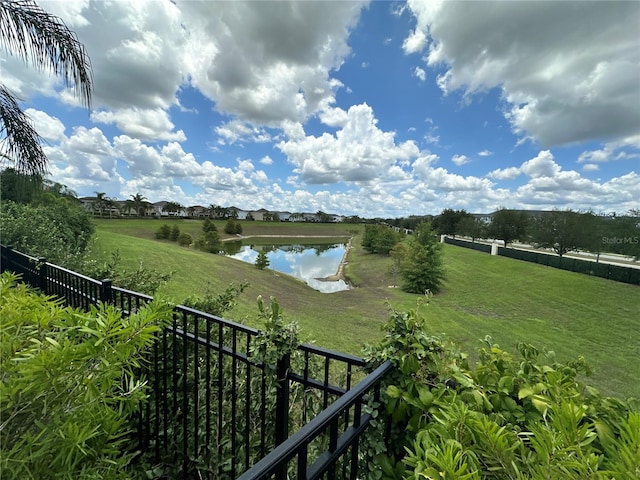 view of yard featuring a water view and fence