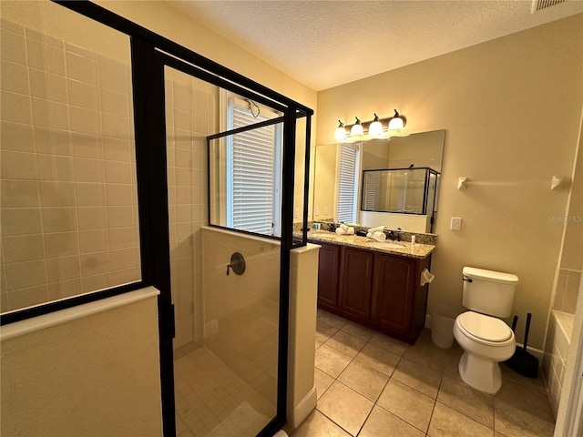 full bath featuring toilet, a shower stall, vanity, a textured ceiling, and tile patterned flooring