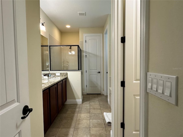 full bathroom with a stall shower, visible vents, baseboards, tile patterned flooring, and vanity