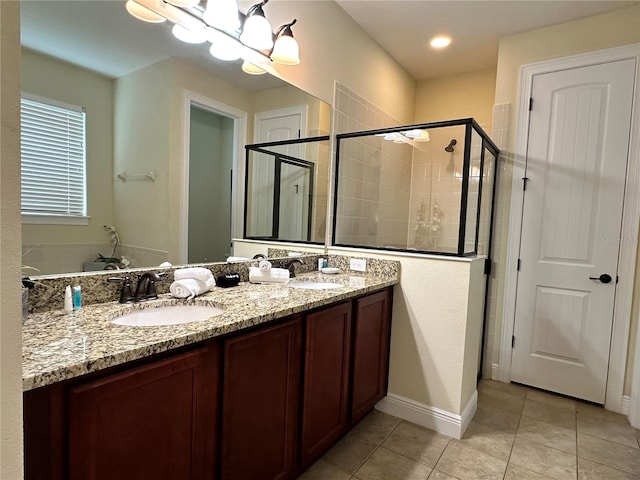 full bath with double vanity, a stall shower, a sink, and tile patterned floors