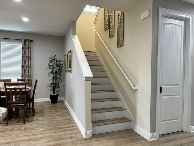 stairs featuring recessed lighting, wood finished floors, and baseboards