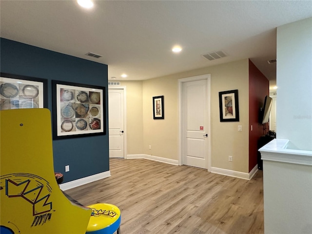 sitting room with light wood-type flooring, visible vents, baseboards, and recessed lighting