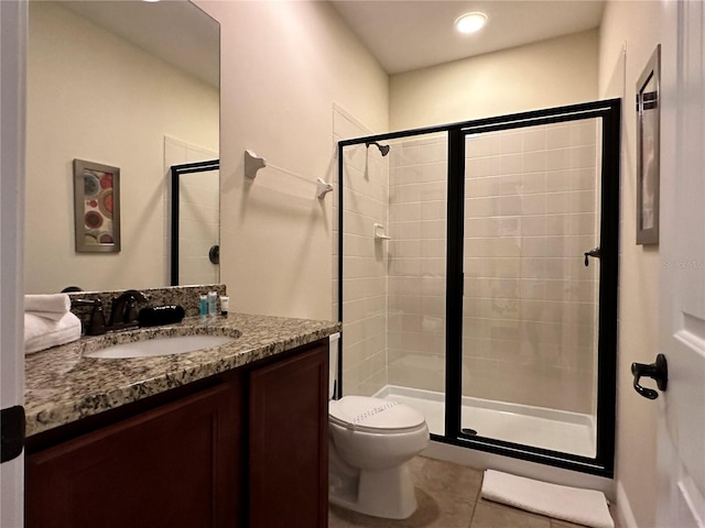 full bath with toilet, a stall shower, tile patterned floors, and vanity