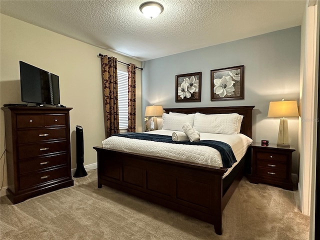 bedroom with a textured ceiling and light colored carpet