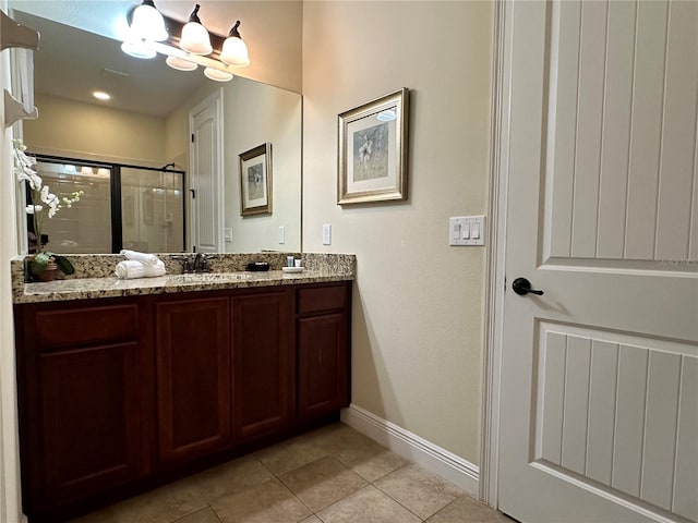 bathroom featuring vanity, baseboards, tile patterned floors, a stall shower, and an inviting chandelier