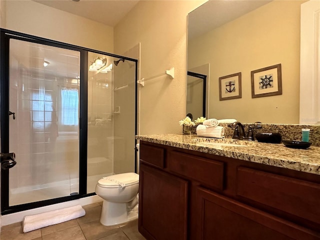 full bathroom featuring a stall shower, tile patterned flooring, vanity, and toilet