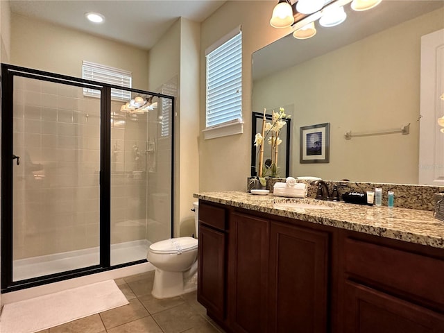 bathroom with toilet, a shower stall, vanity, and tile patterned floors