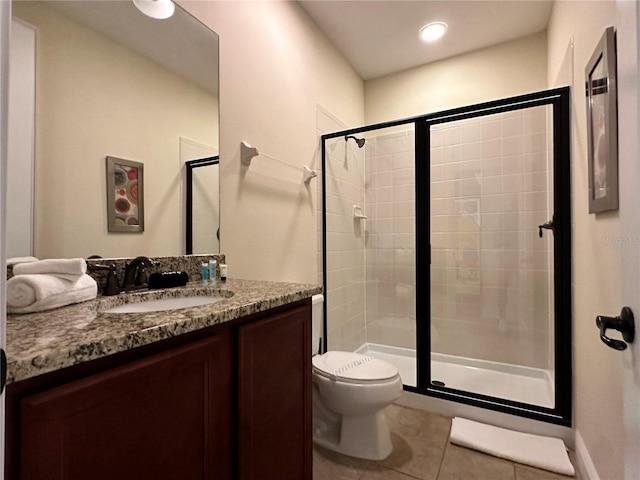 full bathroom with a stall shower, vanity, toilet, and tile patterned floors