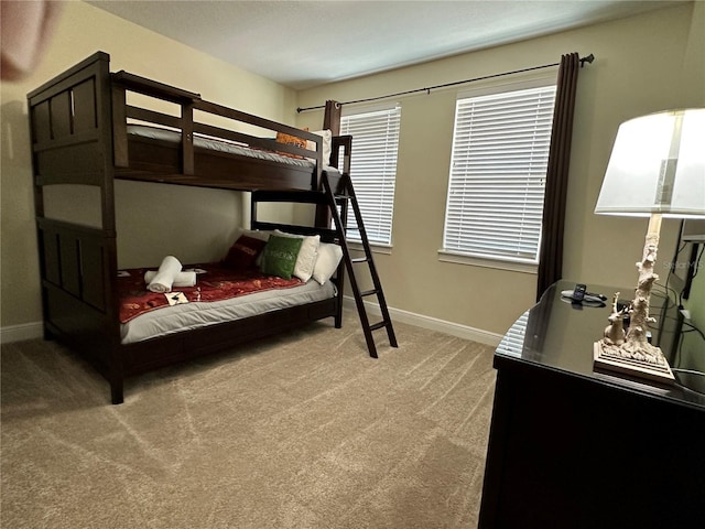 bedroom featuring light carpet and baseboards