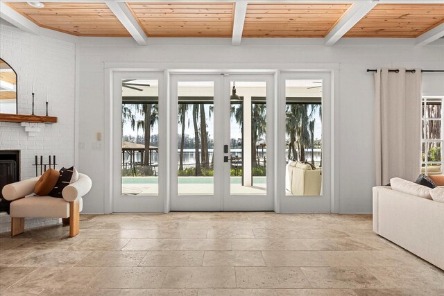 doorway to outside featuring beamed ceiling, plenty of natural light, and wood ceiling