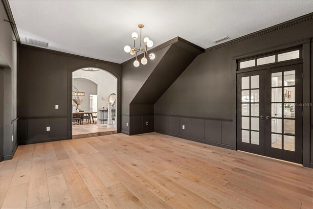 additional living space with hardwood / wood-style flooring, french doors, and visible vents