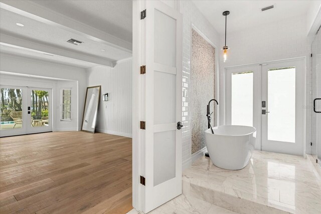 foyer featuring french doors, marble finish floor, visible vents, and beamed ceiling