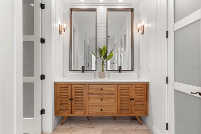 bathroom with double vanity, marble finish floor, and a sink