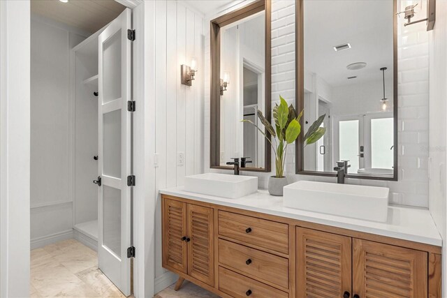 full bath with a sink, visible vents, double vanity, and french doors