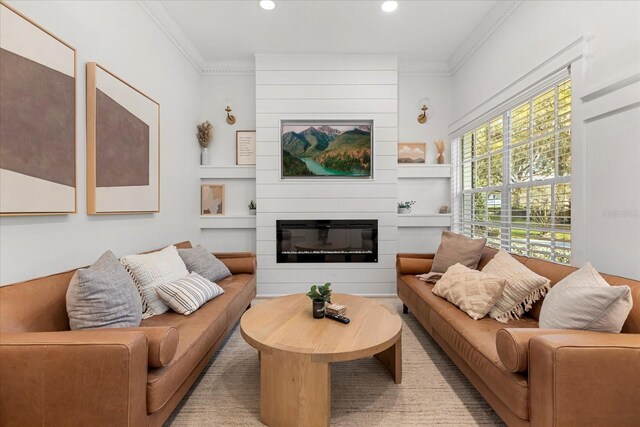 living area with recessed lighting, crown molding, and a large fireplace