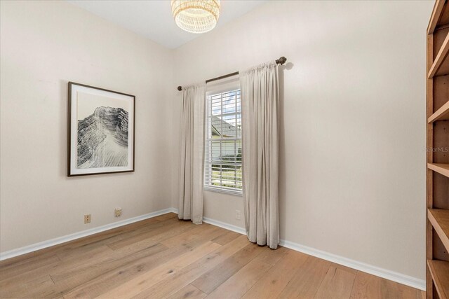 unfurnished room featuring baseboards and light wood finished floors