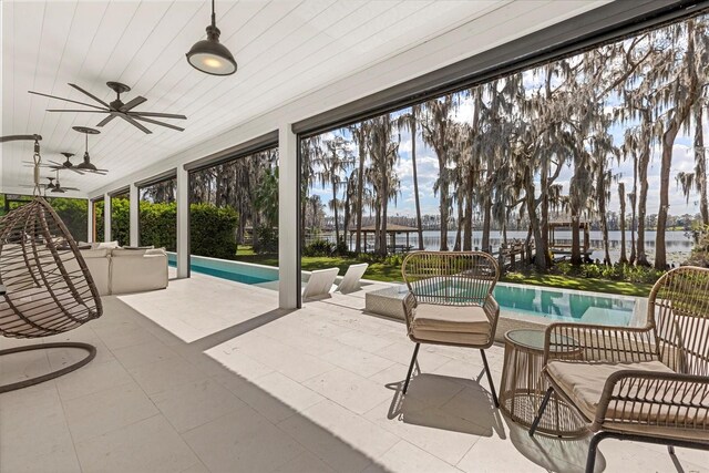 exterior space with an outdoor pool, a water view, and ceiling fan