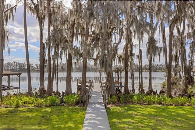 dock area with a yard and a water view