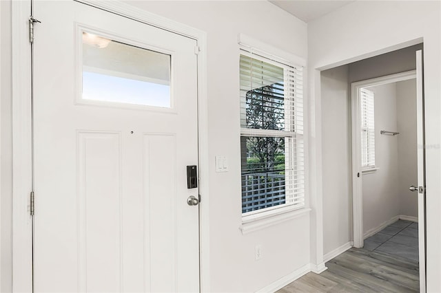 entryway with light wood finished floors and baseboards