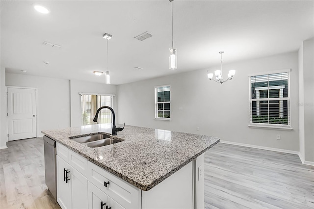 kitchen with visible vents, dishwasher, light wood-style flooring, pendant lighting, and a sink