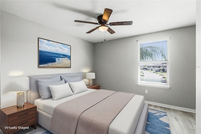 bedroom with ceiling fan, baseboards, and wood finished floors