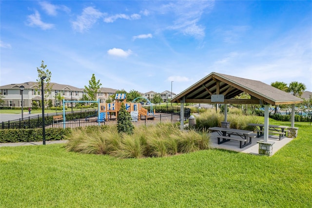 view of property's community featuring a residential view, a yard, fence, playground community, and a gazebo