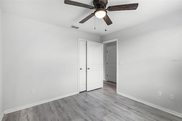 unfurnished bedroom featuring baseboards, visible vents, ceiling fan, and wood finished floors