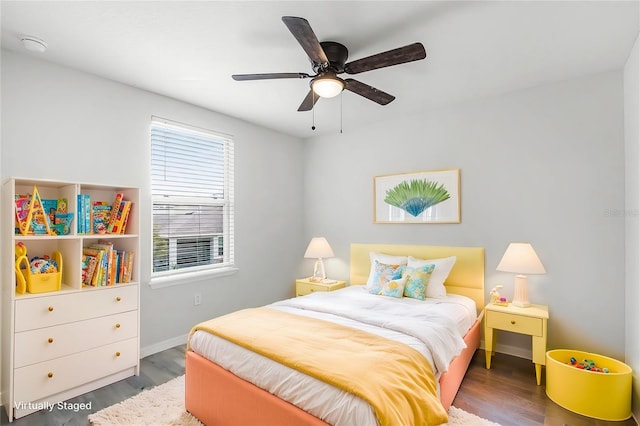 bedroom with ceiling fan, wood finished floors, and baseboards