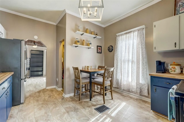 dining room with arched walkways, a healthy amount of sunlight, crown molding, and baseboards