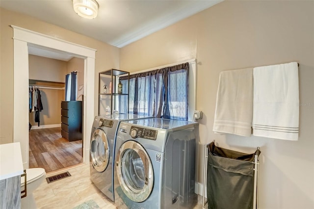 laundry area with laundry area, washer and clothes dryer, and visible vents