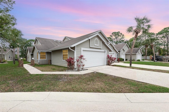 view of front of property featuring a garage, driveway, and a lawn