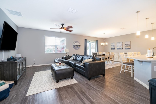 living area with dark wood-style floors, visible vents, and baseboards