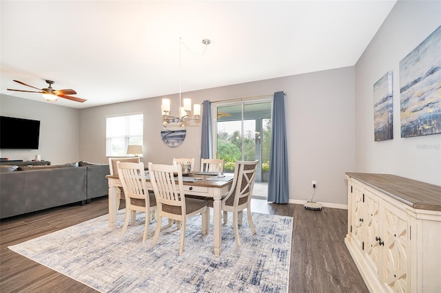 dining room with dark wood-style flooring, baseboards, and ceiling fan with notable chandelier