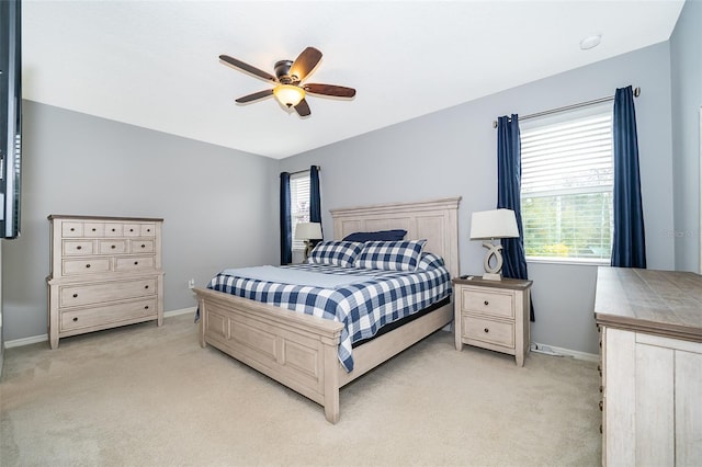 bedroom featuring baseboards, a ceiling fan, and light colored carpet