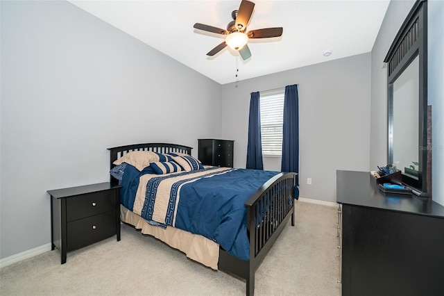 bedroom with light carpet, baseboards, and a ceiling fan