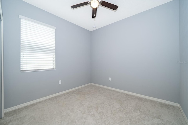 carpeted spare room with ceiling fan and baseboards